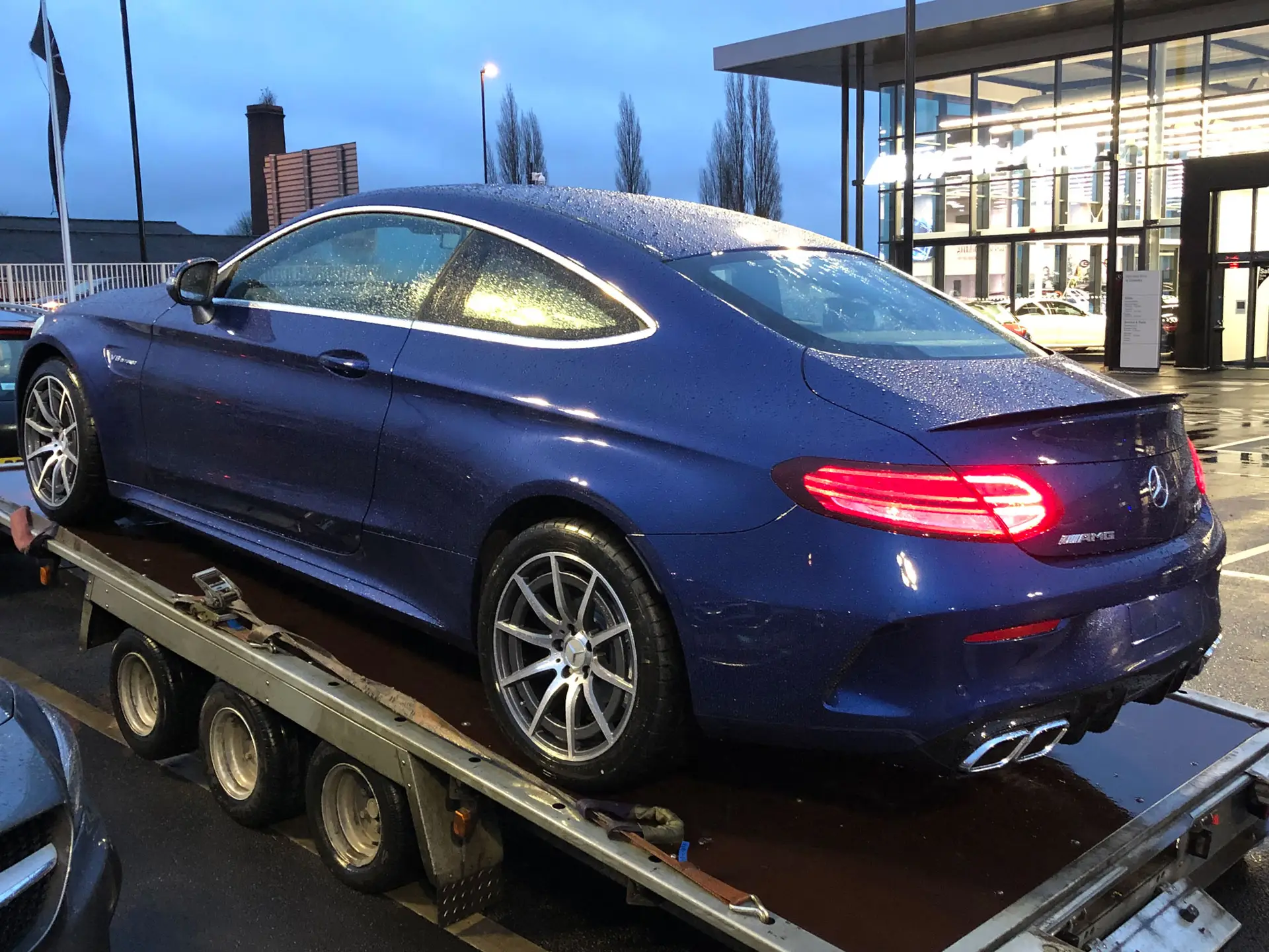 A blue Mercedes coupé strapped down on an ICM trailer