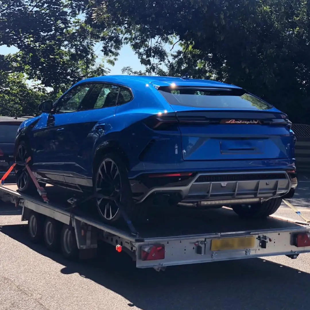 A blue Lamborghini Urus loaded on an ICM trailer